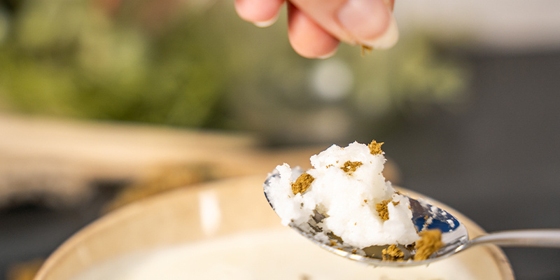 Start by putting a dollop of coconut oil on your spoon.